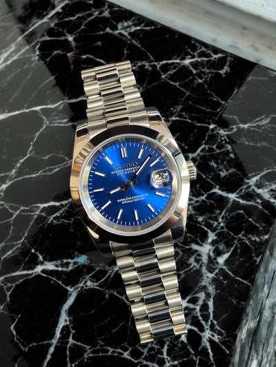 Silver watch with a blue face on a black marble surface