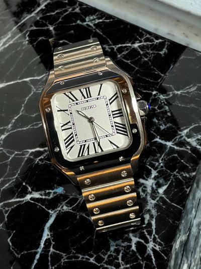 Gold Seiko watch on a black marble surface
