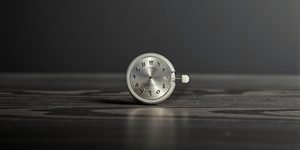Silver pocket watch on a wooden surface with a dark background